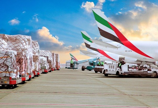 Cargo operations in Dubai and a US visa stamp representing the global impact of US tariff and visa fee changes.