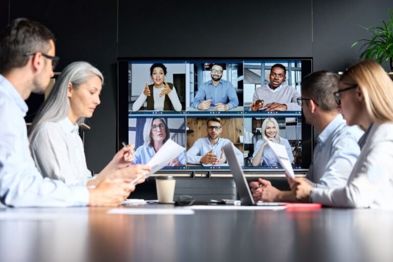 Hybrid work model showing employees collaborating both in-office and remotely.